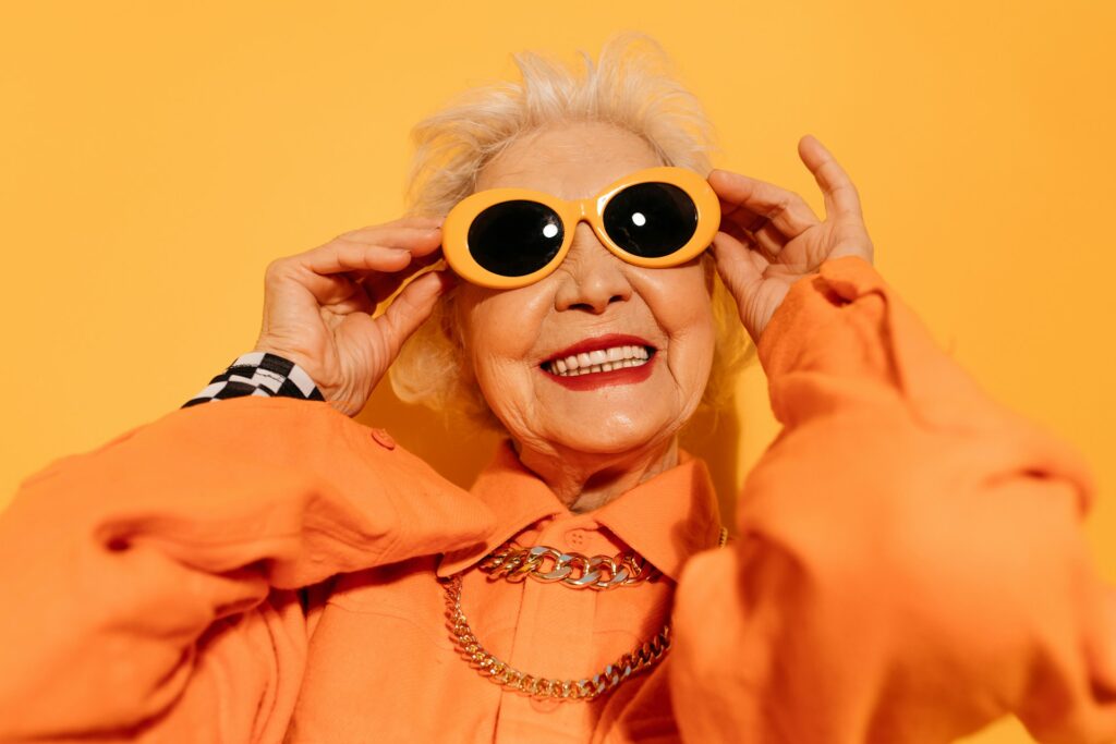 Light skinned female in bright orange clothing with bright  orange sunglasses
